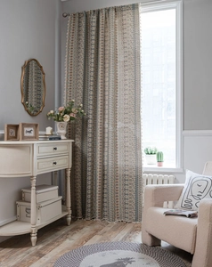 Close-up of bohemian curtain fringe with geometric jacquard pattern in neutral tones