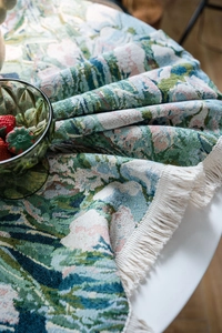 Close-up of vintage floral jacquard tablecloth texture with elegant white fringe