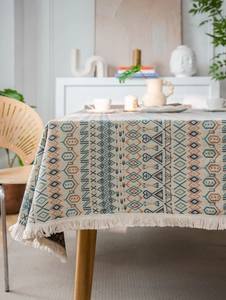 Detail of bohemian geometric jacquard tablecloth with beige tassels and fabric texture