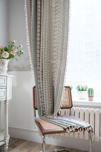 Detail of bohemian geometric print curtain with tassels and cotton linen texture