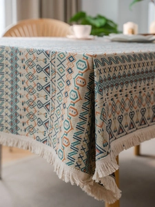 Detail of bohemian jacquard tablecloth featuring geometric patterns and fringe edges