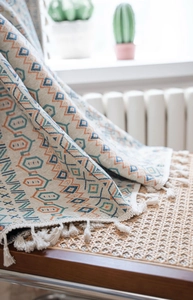 Detail of bohemian geometric jacquard curtain with tassels on a woven chair