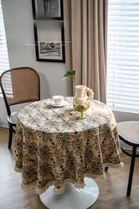 Detail view of American vintage round tablecloth with floral patterns and white fringe trim
