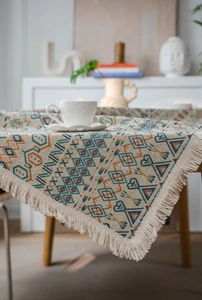 Close-up of bohemian geometric jacquard tablecloth with textured weave and fringe edge
