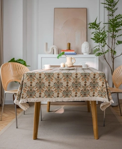Detail einer Vintage-Tischdecke mit Blumenmuster und feinen Quasten am Rand der Decke