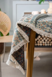 Close-up of bohemian geometric jacquard tablecloth with detailed fringe edges
