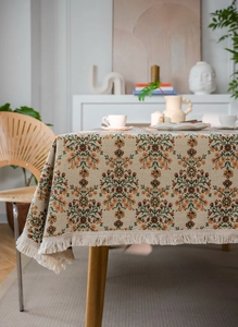 Detail der Vintage-Jacquard-Tischdecke mit Blumenmuster und beigen Fransen am Rand