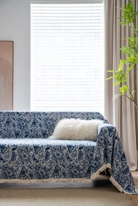 Detail of blue butterfly jacquard sofa cover fabric with elegant cream white fringe tassels