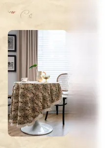 Detailed close-up of vintage floral jacquard tablecloth with white tassel trim decoration