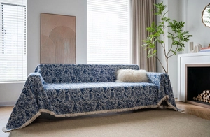 Close-up of blue butterfly floral jacquard sofa cover with elegant yellow tassel fringe detail