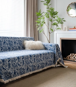 Close-up of blue and white butterfly jacquard sofa cover with elegant fringe details
