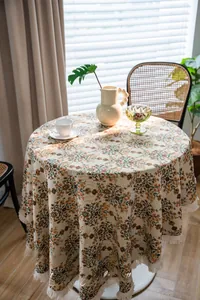 Close-up of jacquard floral round tablecloth with elegant tassel edges in sunlight