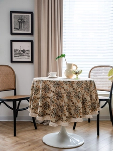 Close-up of vintage floral round tablecloth with elegant fringe tassels and woven texture