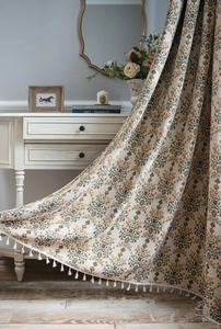 Detailed texture of ivory floral curtains with green jacquard and white tassel fringe edge