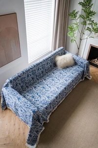 Close-up of blue butterfly jacquard sofa throw cover with decorative tassel fringe details
