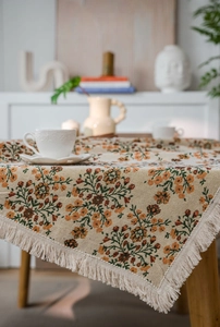 Detailaufnahme der Vintage-Blumen-Jacquard-Tischdecke mit eleganten weißen Fransenquasten