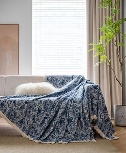 Detail of blue butterfly jacquard sofa throw blanket with decorative hand-knotted tassels