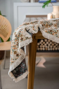 Detailansicht der Boho-Tischdecke mit Blumenjacquard und cremeweißen Fransen am Saum