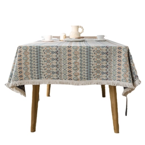 Bohemian geometric jacquard tablecloth with grey-blue stripes and tassels on wooden table