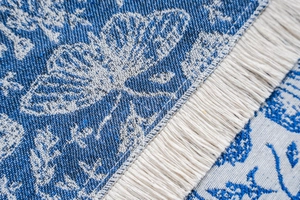 Detailed macro view of blue and white jacquard fabric with elegant tassel fringe