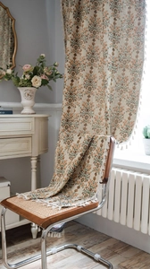 Detailed texture of green floral jacquard fabric with elegant cream tassels fringe