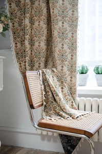 Close-up of green floral jacquard fabric with elegant tassel trim for kitchen windows