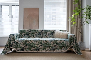 Close-up of green floral jacquard fabric weave with detailed cream fringe edging