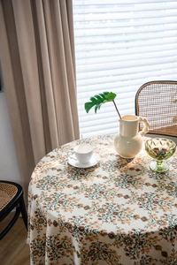 Close-up of thick beige tablecloth with yellow floral patterns and raw edge texture
