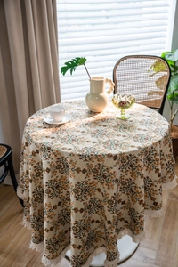 Close-up of retro floral tablecloth with fringe tassels and thick woven texture