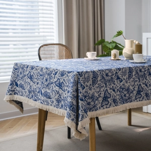Blaue Jacquard Tischdecke mit Schmetterlingsmuster und Fransen auf dem Holztisch