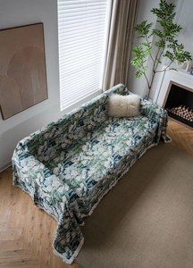 Detail of floral green jacquard sofa cover fabric featuring intricate white fringe edges