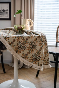 Detail of floral jacquard tablecloth with thick knitted texture and tassel fringe edge