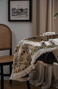 Detail of floral jacquard tablecloth with fringe edges and vintage weaving texture