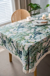 Detail of bohemian floral jacquard tablecloth featuring elegant white tassel edges