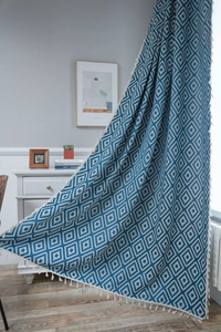 Detailed texture of blue geometric diamond pattern curtain with white decorative tassels
