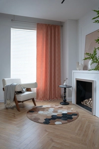 Detail of green striped curtains with orange geometric diamond patterns and tassel trim
