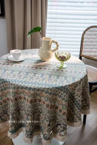 Close-up of geometric jacquard tablecloth with bohemian tassels in blue and orange