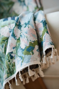 Detail showing green floral jacquard fabric with elegant cream white tassel fringes