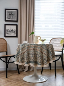 Detail of bohemian geometric pattern tablecloth with cream tassel fringe on round table