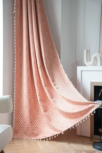 Detail of peach geometric diamond curtain with white tassels and woven texture finish