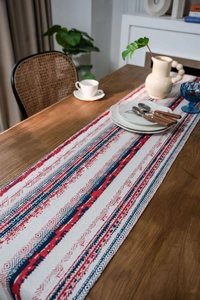 Detailed view of bohemian geometric pattern table runner on a dark wood dining table