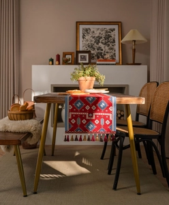 Close-up of red jacquard table runner with bohemian geometric patterns and tassels