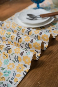 Floral table runner with yellow and blue flowers on linen fabric with tassel details