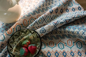 Detailed close-up of geometric jacquard tablecloth with bohemian patterns and woven texture