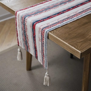 Ethnic bohemian table runner with blue and red geometric stripes and white tassels
