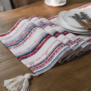 Ethnic style geometric table runner with red blue patterns and white cotton tassels