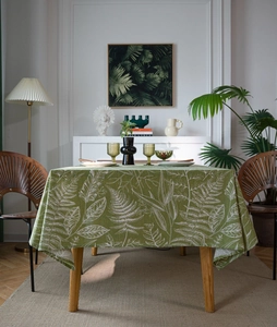 Detail of green tablecloth with white fern leaf patterns in a natural home setting