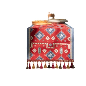 Ethnic style red table runner with jacquard geometric patterns and colorful tassels