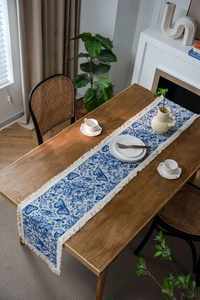 Dettaglio del runner da tavola jacquard con farfalle blu e nappe con frange bianche