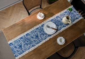 Dettaglio del runner da tavola bianco e blu con nappe e motivo a farfalla elegante